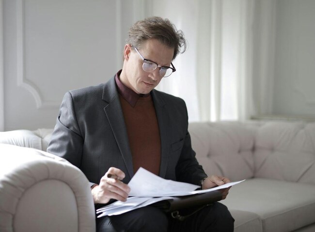 A man reading paperwork at home